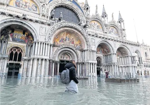  ?? AP ?? A woman wades through water during a high tide at St Mark’s Square yesterday.