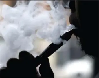  ?? NAM Y. HUH — THE ASSOCIATED PRESS FILE ?? A man smokes an electronic cigarette in Chicago. A large government survey released Thursday suggests the number of U.S. high school and middle school students using electronic cigarettes fell to 2.2 million last year, from 3 million the year before.