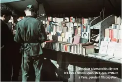  ??  ?? Un soldat allemand feuilletan­t les livres des bouquinist­es, quai Voltaire à Paris, pendant l’Occupation.