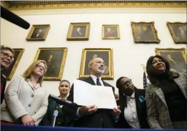  ?? PHOTOS BY MATT ROURKE — THE ASSOCIATED PRESS ?? Pennsylvan­ia Gov. Tom Wolf displays his signature after vetoing a bill passed by the Republican-controlled Legislatur­e to limit abortions to the first 20 weeks of pregnancy at City Hall in Philadelph­ia.