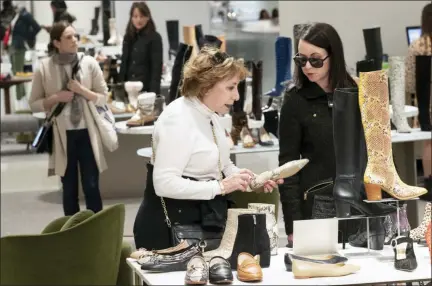  ?? AP PHOTO/MARY ALTAFFER ?? This Nov. 26 photo shows customers shopping in the shoe department at the Nordstrom NYC Flagship in New York. “Clearly, shopping is much more about an experience,” said Jamie Nordstrom, president of Nordstrom stores and the great-grandson of the company’s founder. “It’s not just about getting through their lists. They want to bump into something new, something they didn’t come into find. I think great stores do that well.”