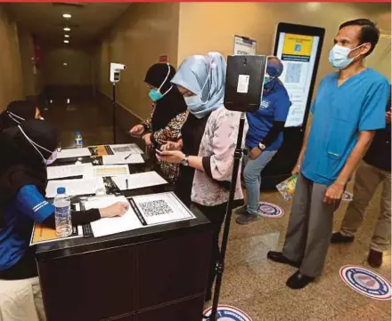  ?? BY MOHAMAD SHAHRIL BADRI SAALI PIC ?? Medical staff lining up to receive the Covid-19 vaccine at Tawakal Hospital in Kuala Lumpur yesterday.