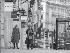  ??  ?? LONDON
Two women walk down Regent Street, one of London's main shopping streets, as Britain continues its third COVID-19 lockdown, in London, Britain. -REUTERS