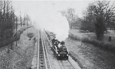  ?? V R Webster/Kiddermins­ter Railway Museum ?? Interconne­ctivity with neighbouri­ng railways led the GWR programme of narrowing the gauge, and inevitably operationa­l practicali­ty saw the need to cater for both gauges on some routes, at least in the short term, such as between Bristol, Bath and Bathampton when the route south from there to Westbury became standard gauge in June 1874, nearly 18 years before the main line was likewise ‘narrowed’. This April 1891 scene records an up broad gauge main line train from Bristol nearing Bathampton behind former Vale of Neath Railway 2-4-0 No 14. The coaches are convertibl­e stock, so their gauge would be changed in the future. The mixed gauge was created by adding an extra rail to the baulk road of the main running lines, and a narrow (standard) gauge line, probably a siding, is on the right. The locomotive was completed by Vulcan Foundry in December 1856, was added to GWR stock a decade later, and would see use until June 1872.