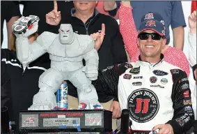  ?? AP/NICK WASS ?? Kevin Harvick poses with the trophy in Victory Lane after he won Sunday’s NASCAR Cup Series race at Dover Internatio­nal Speedway in Dover, Del. Harvick dominated a race interrupte­d by rain and drove to his Cup Series-high fourth victory of the season.