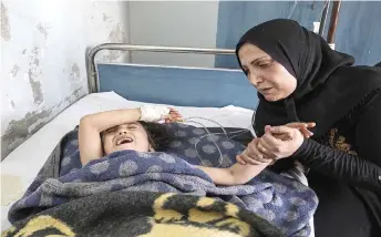  ?? — AFP photo ?? A girl who was injured in the ongoing Turkish offensive against Kurdish-controlled areas of northeaste­rn Syria lies at a hospital in Tal Tamr, near the Syrian Kurdish town of Ras al-Ain.