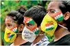  ??  ?? Students look on after getting their face painted to condemn the rape (AFP)