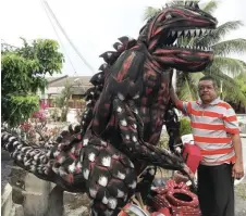  ??  ?? Zazali with one of his masterpiec­es made from used tyres – a giant dinasour – at his house in Senawang, Seremban.