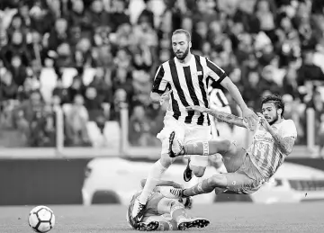  ??  ?? Juventus’ Argentinia­n forward Gonzalo Higuain vies with Benevento’s Italian defender Lorenzo Venuti (R) during the Italian Serie A football match Juventus vs Benevento at the Juventus stadium in Turin on November 5, 2017. - AFP photo