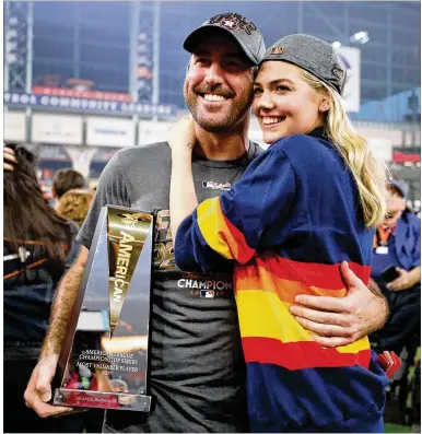  ?? RONALD MARTINEZ / GETTY IMAGES ?? Justin Verlander, holding the ALCS MVP trophy, and fiancee Kate Upton are all smiles after the Astros defeated the Yankees 4-0 in Game 7 on Saturday. Verlander is 4-0 with a 1.46 ERA in the playoffs this season.