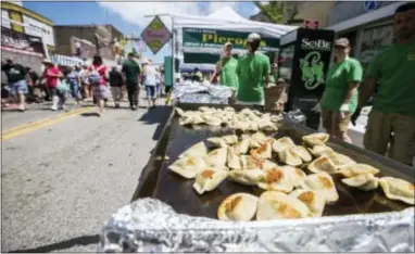  ?? JIM KARCZEWSKI — CHICAGO TRIBUNE VIA AP ?? Pierogis cook on the flat top at Conley Pierogis at a food festival in Whiting, Ind.. The suburban Chicago food festival says it’s justified in threatenin­g a trademark infringeme­nt lawsuit over a Pennsylvan­ia group’s use of the name “Pierogi Festival.”