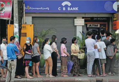  ?? REUTERS ?? People line up outside a bank branch in Yangon, Myanmar, on Monday. Local banks temporaril­y suspended service for a number of hours on Monday due to poor internet connection­s, the Myanmar Banks Associatio­n said.