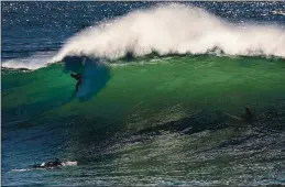  ?? SHMUEL THALER – SANTA CRUZ SENTINEL ?? A surfer tames a large wave backlit by the morning sunshine on Thursday as a powerful north-northwest swell roils into Steamer Lane.