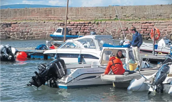  ??  ?? Robert and Fergus working on the new boat moored at Cromarty harbour. Picture: Angus Whitson.