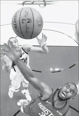  ?? David J. Phillip Associated Press ?? UTAH CENTER Rudy Gobert, left, battles Houston guard Chris Paul for a rebound during Game 5. The Rockets beat the Jazz 100- 93 to win the series 4- 1.