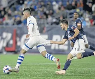  ?? ASSOCIATED PRESS ?? SHORT GAME: Kelyn Rowe gets a handful of Saphir Taider’s uniform during the Revs’ 1-0 win last night in Foxboro.