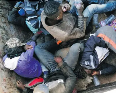  ?? JU DENNIS / THE ASSOCIATED PRESS ?? Migrants expelled from Algeria huddle for shade in a truck on May 9, as they head toward the Niger border before embarking on a perilous 16-kilometre walk through the Sahara Desert toward the border. Many died en route.