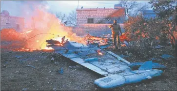  ?? AFP ?? FUEGO. Un combatient­e islámico fotografía los restos de la nave derribada y la turbina de la máquina. Según Moscú, el piloto trató de usar su arma, pero fue abatido.