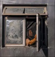  ?? ?? Li closes his windows Aug. 15 at his home in Hong Kong.