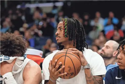  ?? CHRIS DAY/THE COMMERCIAL APPEAL ?? Grizzlies’ Ja Morant holds a basketball that rolled from the court to the bench during the game between the Memphis Grizzlies and the Dallas Mavericks at Fedexforum in Memphis on Monday.