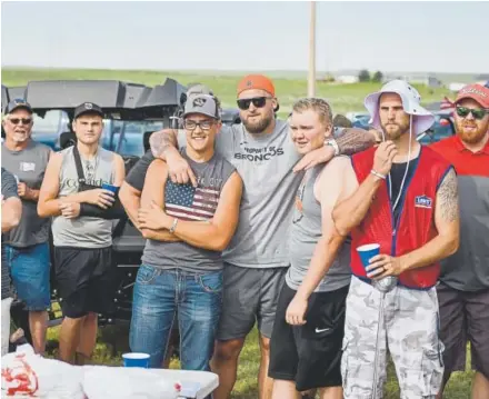  ?? Photos by Michael Ciaglo, Special to The Denver Post ?? Broncos rookie offensive lineman Dalton Risner, center, listens as his father reads off the golf scramble rules before the annual Risner Classic Golf Tournament on their family farm in Wiggins on Saturday.