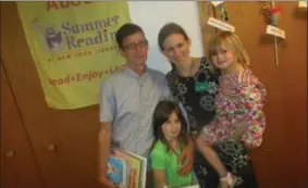  ?? PHOTO SPECIAL TO THE DISPATCH BY MIKE JAQUAYS ?? Amy Sommers, center, poses with husband Joel and their children Halima, 8, and Nina, 4, at the Hamilton Public Library on June 19.