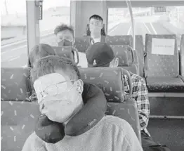  ?? KIN CHEUNG/AP ?? A passenger with a travel pillow sleeps on a bus Oct. 16 in Hong Kong. A company offers fivehour bus tours of the territory to help residents get some sleep.