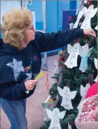  ?? WILLIAM HARVEY/THREE RIVERS EDITION ?? Paula Cornell puts new last-minute angels on the Angel Tree inside the Walmart Supercente­r in Beebe.