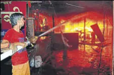  ?? PARDEEP PANDIT/HT ?? A firefighte­r dousing the flames at Sudama Market in Jalandhar on Thursday.