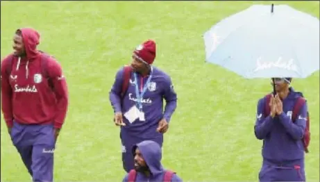  ??  ?? West Indies players stroll across the field at Old Trafford during the rain delay.