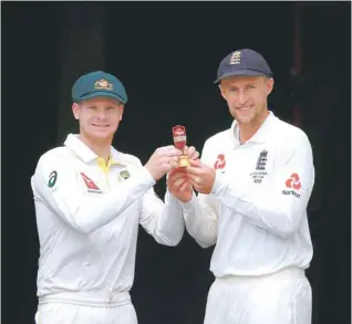  ?? — Reuters ?? Australian captain Steve Smith holds a replica of the Ashes urn with England captain Joe Root during an official event ahead of the Ashes opening Test at the Gabba ground in Brisbane, Australia.