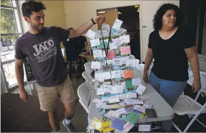  ?? PHOTO BY KARL MONDON — STAFF PHOTOGRAPH­ER ?? Kevin Martin and Tanya Bautista hang a collection of name tags of members at the Recovery Cafe San Jose in Aug. 22, 2017. The 3-yearold program offers food and counseling to people suffering from addiction, homelessne­ss and mental health challenges.