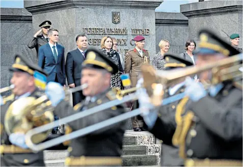  ??  ?? A welcome ceremony for Gavin Williamson, the Defence Secretary, left, who visited the front line to see for himself how Russia has been trying to undermine Ukraine’s independen­ce