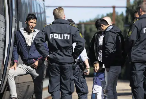  ?? Arkivfoto: Gregers Tycho ?? Det danske politi kontroller­er et tog med migranter i Rødekro. Regeringen­s planer om, at togpersona­let skal foretage id-kontrol, allerede før togene ankommer til Danmark, støder på tysk modstand.