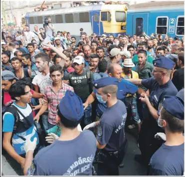  ??  ?? DERAILED: Hungarian police stop migrants from boarding trains in Budapest yesterday