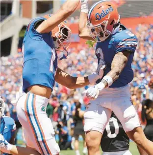  ?? STEPHEN M. DOWELL/ORLANDO SENTINEL ?? Florida wide receivers Chimere Dike, left, and Eugene Wilson III celebrate after a Wilson touchdown during the Orange & Blue spring game at Ben Hill Griffin Stadium in Gainesvill­e on Saturday.