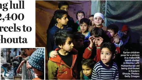 ??  ?? Syrian children pose for a picture in a makeshift bomb shelter in Douma. Left: Humanitari­an aid being distribute­d in Eastern Ghouta. Photos: Getty Images