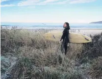  ?? PHOTO: JOHN LESLIE ?? A thick frost on Warrington Beach was not going to stop Greta Mutch from heading out to catch a few waves last week.