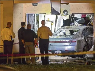  ?? LANNIS WATERS / THE PALM BEACH POST ?? Deputies examine the scene where two men died when their car slammed into a home in a Greenacres­area apartment complex early Wednesday following a reported shooting.