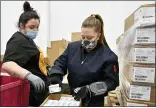  ?? AP PHOTO/TIMOTHY D. EASLEY, POOL ?? Employees with the McKesson Corporatio­n scan a box of the Johnson and Johnson COVID vaccine as she fills an order at their shipping facility in in Shepherdsv­ille, Ky., Monday, March 1, 2021.