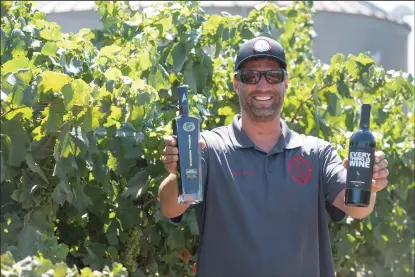  ??  ?? Above: E2 Family Winery’s manager Brett Ehlers holds bottles with specially designed wine labels in the family’s Lodi vineyard on Thursday. Left: E2 Family Winery produces wines with pop culture labels for Wines That Rock, which “connects brands and fans.” On the the right is the Special Reserve Star Trek label on a bottle of Old Vine Zinfandel.