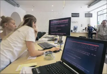  ?? PHOTO: BLOOMBERG ?? Employees read a ransomware demand for the payment of $300 worth of Bitcoin on computers infected by the “Petya” software virus in a retail store in Kiev, Ukraine, on Wednesday. The cyberattac­k similar to WannaCry began in Ukraine on Tuesday.