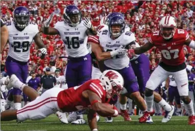  ?? MORRY GASH — THE ASSOCIATED PRESS ?? Wisconsin’s Jonathan Taylor dives into the end zone for a touchdown against Northweste­rn on Saturday.