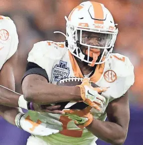  ?? CALVIN MATTHEIS/NEWS SENTINEL ?? Tennessee running back Jabari Small grabs the ball from quarterbac­k Hendon Hooker (5) at the Music City Bowl last season.