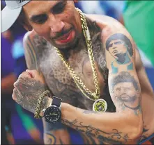  ?? *REUTERS ?? An Argentina fan shows off his Diego Maradona and Lionel Messi tattoos at Lusail Stadium in Qatar on Saturday.