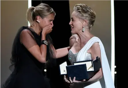  ?? AFP. ?? Julia Ducournau recibe con emoción la Palma de Oro de manos de la actriz Sharon Stone.