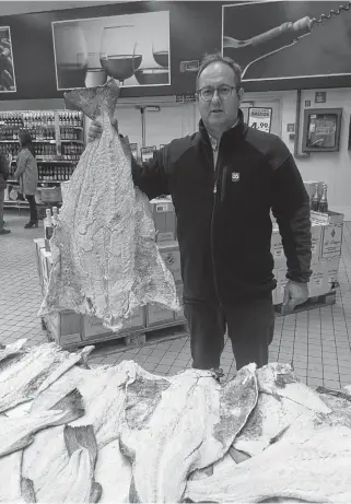  ??  ?? Paul Grant, vice-president of Beothic Seafoods in Valleyfiel­d, N.L, displays a salt cod at a market in Lisbon, Portugal. In the Portuguese and Spanish cultures, salted fish is a traditiona­l food and a staple in their diet.