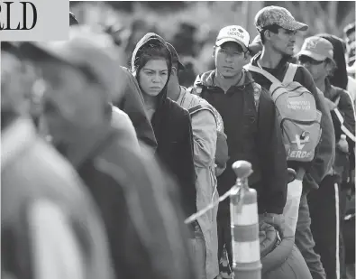  ?? GREGORY BULL/THE ASSOCIATED PRESS ?? Central American migrants wait in line for a meal at a shelter in Tijuana, Mexico, on Wednesday as the first sizable groups in the caravan fleeing violence in their home countries began arriving in the border city of Tijuana.