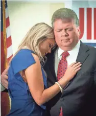  ?? BARBARA GAUNTT/CLARION LEDGER ?? Annabelle Hood leans on her father, Jim Hood, as a closing prayer is said after Hood addressed his supporters at the King Edward Hotel on Tuesday in Jackson, Miss. Before speaking, Hood conceded the race for governor, calling Republican Tate Reeves to congratula­te him.