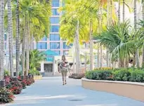  ?? SUN-SENTINEL ?? A woman walks through Boca Center, near where the city is proposing improved lighting, crosswalks, trees and roundabout­s.